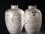 two vases sitting side by side on a black background