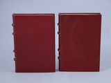 two red book cases sitting side by side on a white surface