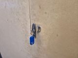a blue padlock on the door of a bathroom stall