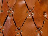 a close up of a brown leather bag with rivets on it