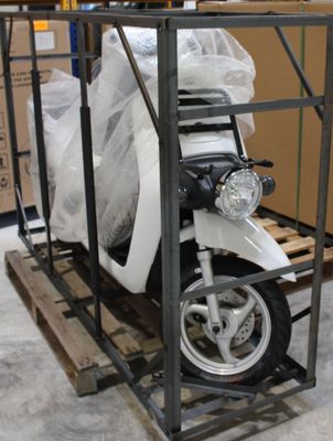 un scooter posé sur une palette dans un entrepôt
