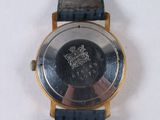a close up of a watch on a white surface