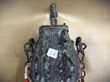 a vase with a statue on top of it on a table
