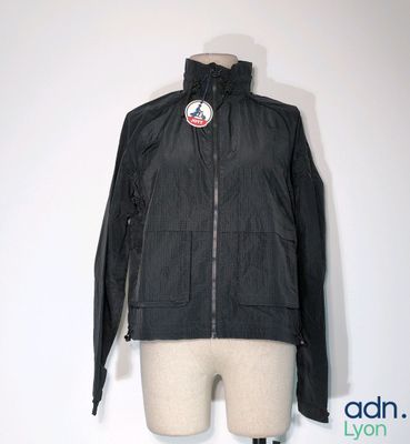 une veste noire posée sur un mannequin, sur fond blanc