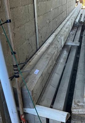 un tas de planches de bois posé contre le mur d'un immeuble