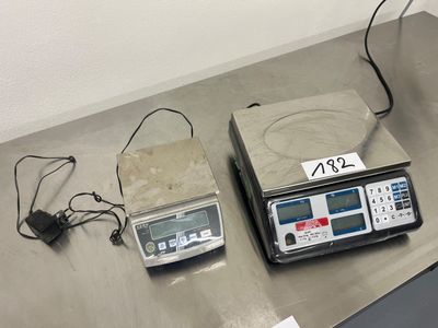 deux balances électroniques posées sur une table, avec une étiquette de prix