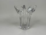 vase en verre transparent posé sur une surface blanche, avec un fond blanc