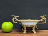 a green apple next to a white bowl on a wooden table