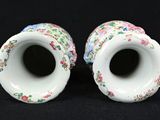 two vases with flowers on them on a black background