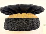 un gros plan d'un chapeau noir et jaune posé sur une surface blanche