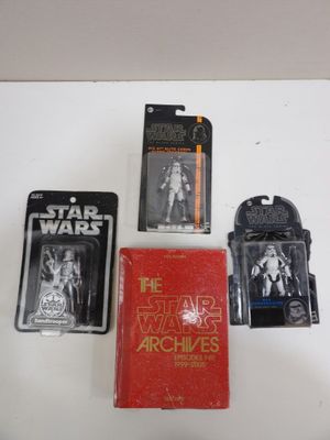Plusieurs figurines de Star Wars sont exposées sur une surface blanche
