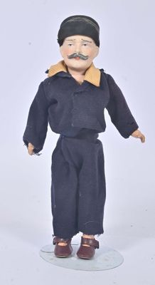 a doll of a man with a mustache on a white surface