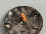 a metal button with a wooden handle on a table