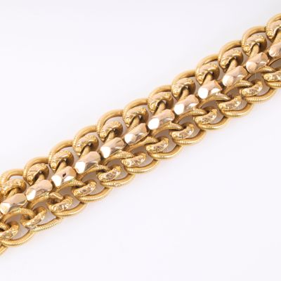 a close up of a gold chain bracelet on a white surface