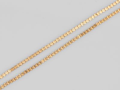 une paire de colliers à chaîne en or sur fond gris