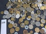 a pile of coins sitting on a table next to a jar of coins