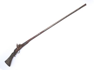 un vieux fusil avec une poignée en bois sur fond blanc
