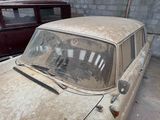 two old cars that are parked in a garage