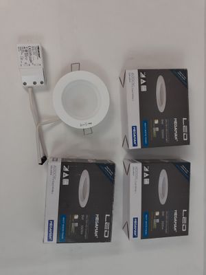 three boxes of white lighting sitting on top of a white table