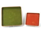 pair of orange and green trays sitting on a white surface
