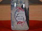 a bottle with a bird on it sitting on a table