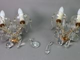 two glass sconces that are sitting on a table