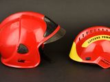 pair of red and yellow firefighter ' s helmets on a black background
