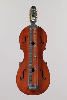 un vieux violon suspendu au plafond, sur lequel repose une guitare