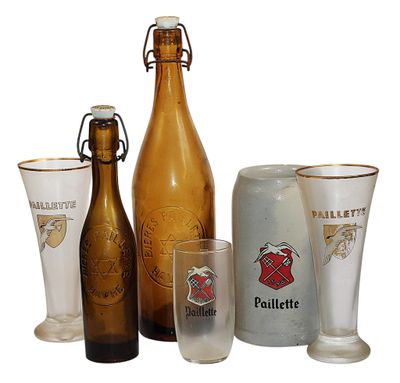 des bouteilles et des verres sont alignés les uns à côté des autres sur une surface blanche