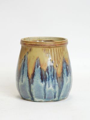 a blue and yellow vase with a mountain design on it