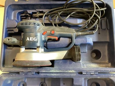 a small electric sander in a plastic case on a table