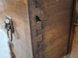 close up of a wooden drawer with a metal latch on top of it