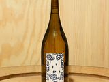une bouteille de vin posée sur un tonneau