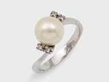 a white pearl and diamond ring on a white background