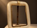 sculpture représentant un objet de forme carrée d'où sort un bâton en bois sur le côté