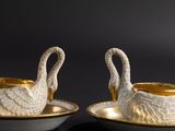 two cups and saucers that are sitting on a table
