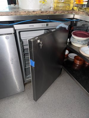 un petit réfrigérateur dans un coin de la cuisine
