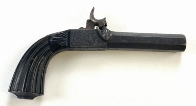 un vieux pistolet avec une poignée en bois sur une surface blanche