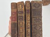 several old books are stacked on top of each other on a table