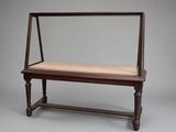 an old wooden bench with a cushion on top of it