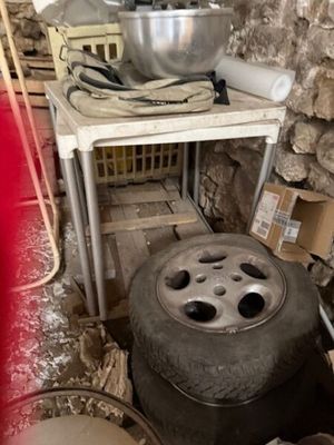 une table sur laquelle est posé un saladier, à côté d'un tas de pneus