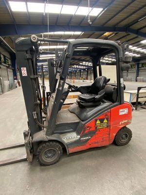 a red fork truck that is parked in a warehouse