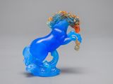 a blue glass horse that is standing on its hind legs