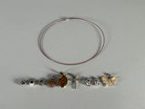 a necklace with a cross, a cow, and other charms on it