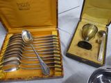 a lot of silver spoons in a box on a table