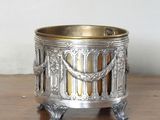 un petit bougeoir en argent posé sur une table en bois