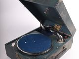 un tourne-disque bleu dans une valise, sur fond blanc