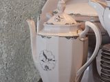 a white tea pot sitting on top of a wooden table