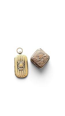 two gold - plated pendants with a design of a bird and a bird on it