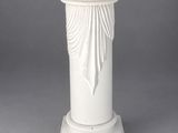 an image of a white marble pedestal with a draped cloth on top